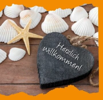 Muscheln und ein Herz mit Herzlich willkommen-Aufschrift