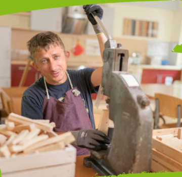 Ein junger Mann schneidet mit einer Maschine Holzklötze