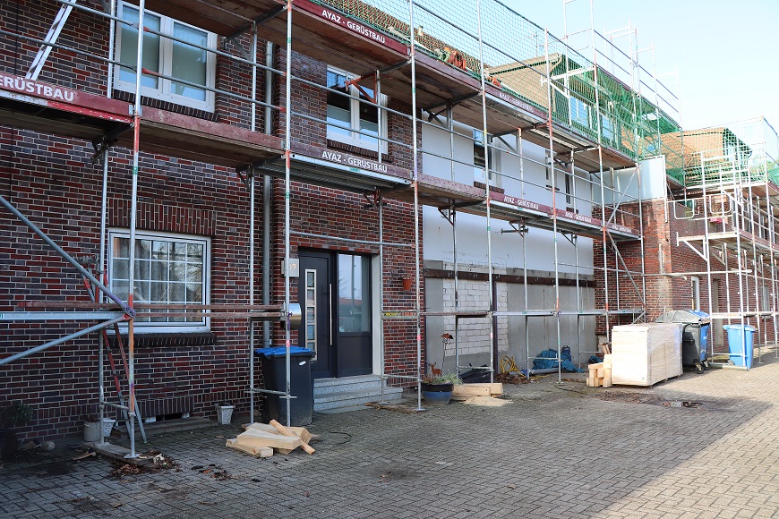 Man sieht eine Baustelle draußen. Ein Haus wird fertig gebaut.