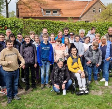 Eine Gruppe junger Menschen und der Einrichtungsleiter Friedrich Fittje draußen im Garten. Ein Gruppenfoto von der Dorfschule Mansie.