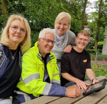 GPS Mitarbeiterinnen mit zwei Männern draußen im Garten am Tisch
