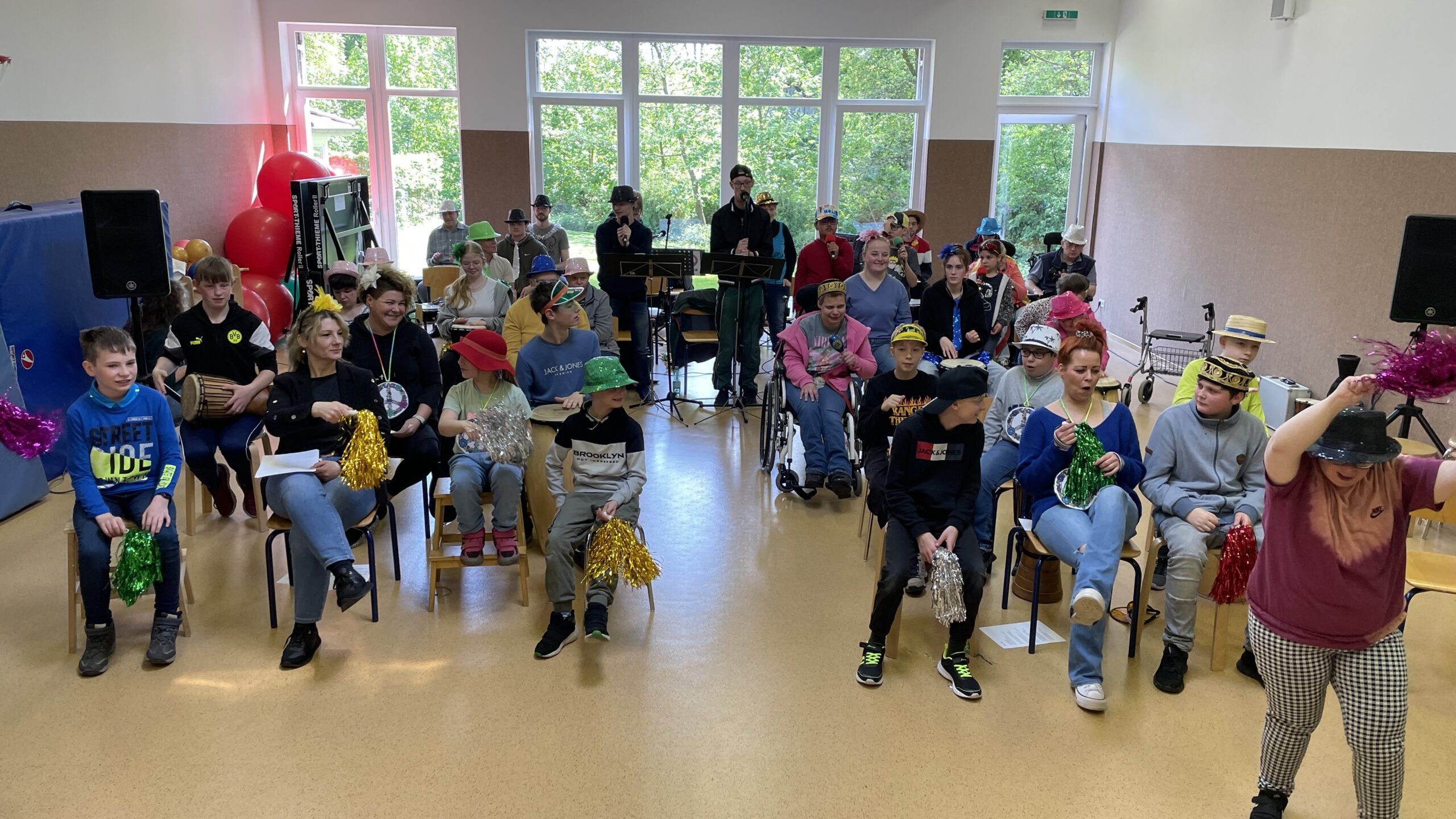 Eine Musikgruppe in einem Raum. Die Gruppe macht Musik mit Gesang und macht Musik mit Musikinstrumenten.