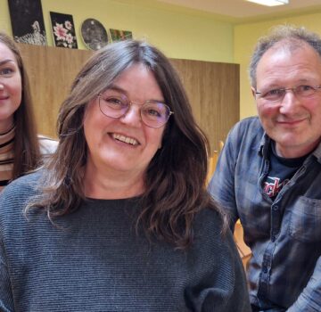 Gruppenfoto mit zwei GPS Mitarbeiterinnen und einen GPS Mitarbeiter von der GPS Tagesstätte Ebkeriege in einem Raum vor der Kamera.