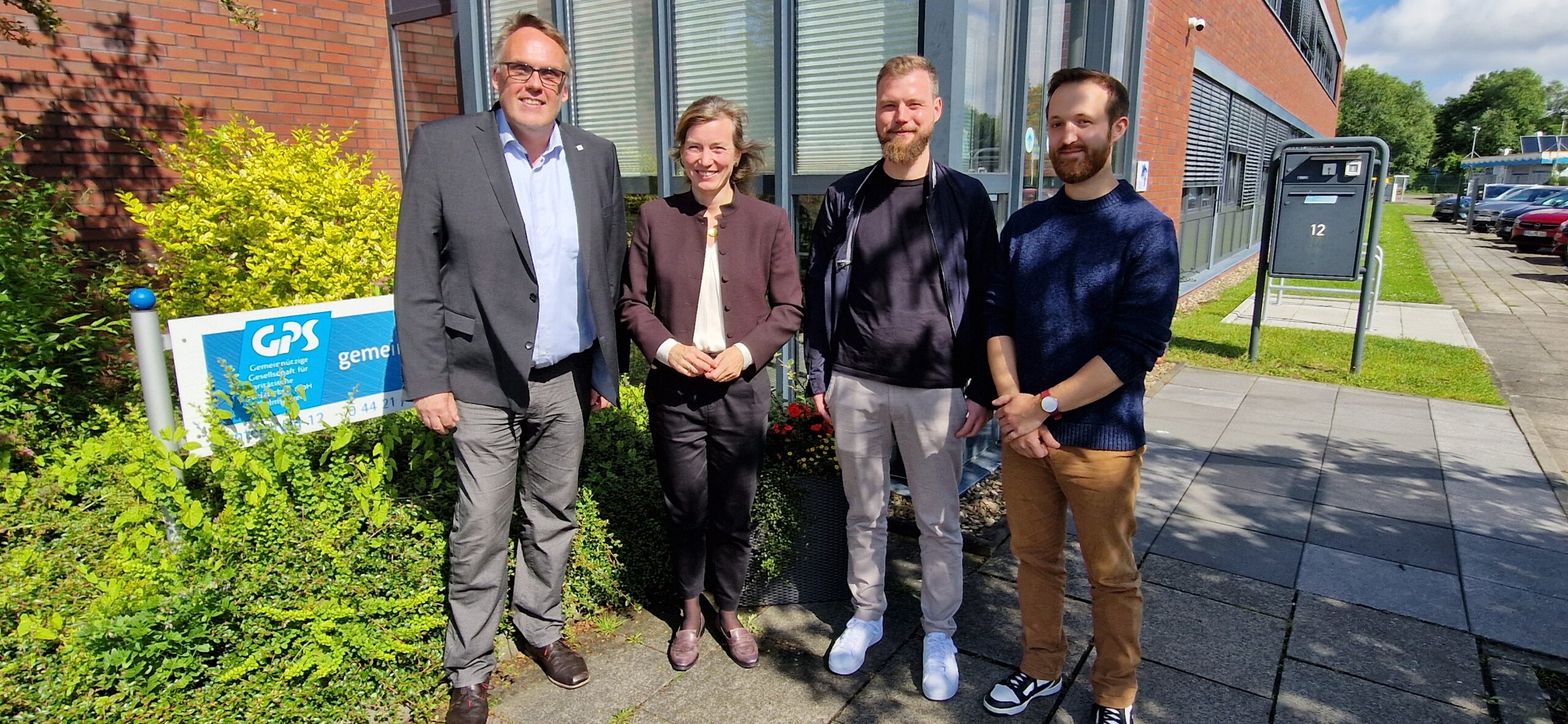 Gruppenfoto vor der GPS Verwaltung mit dem Geschäftsführer der GPS, zwei GPS Mitarbeiter und die Poltikerin Siemtje Möller