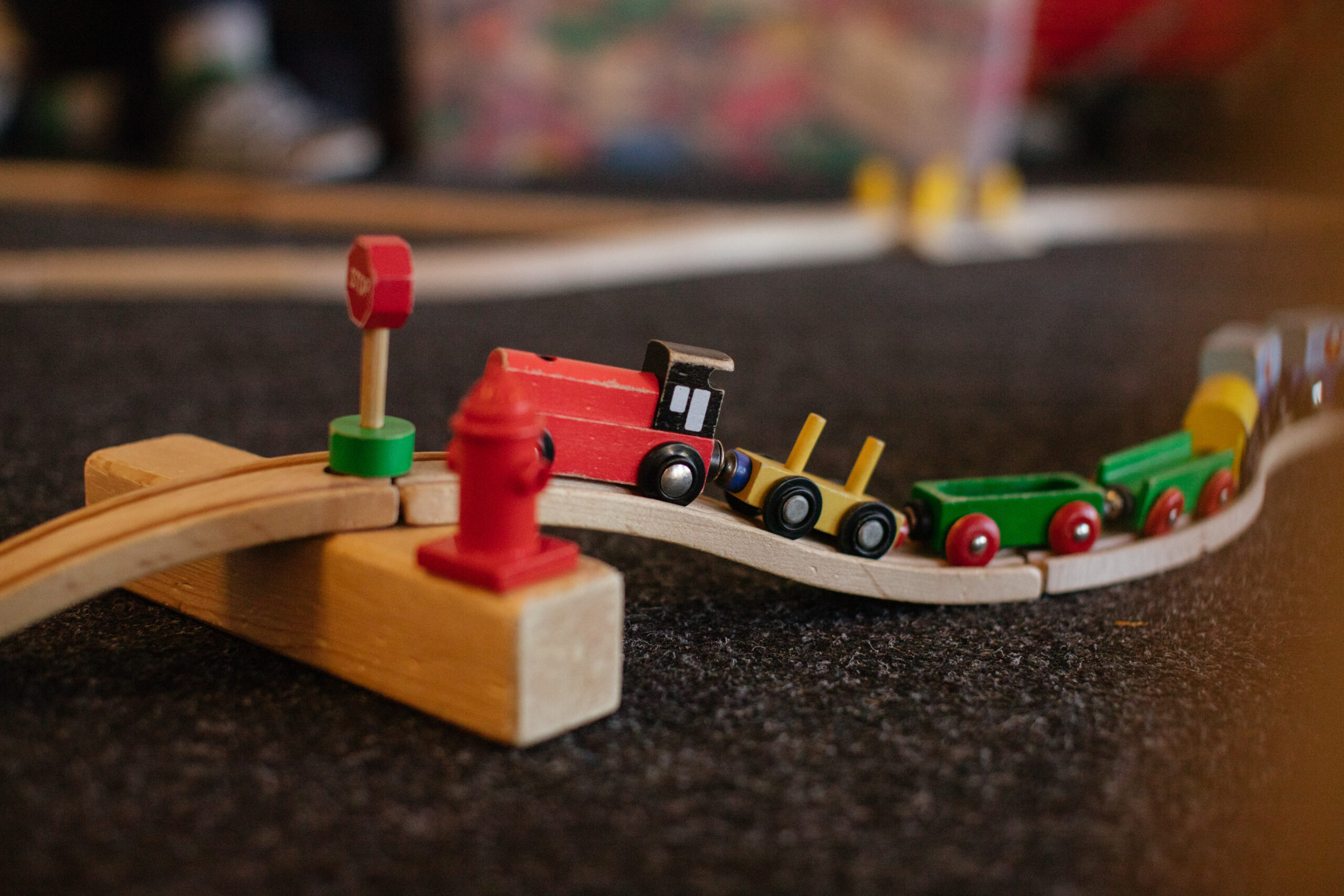 Eine Spielzeugeisenbahn mit Waggons und einer Bahn aus Holz.