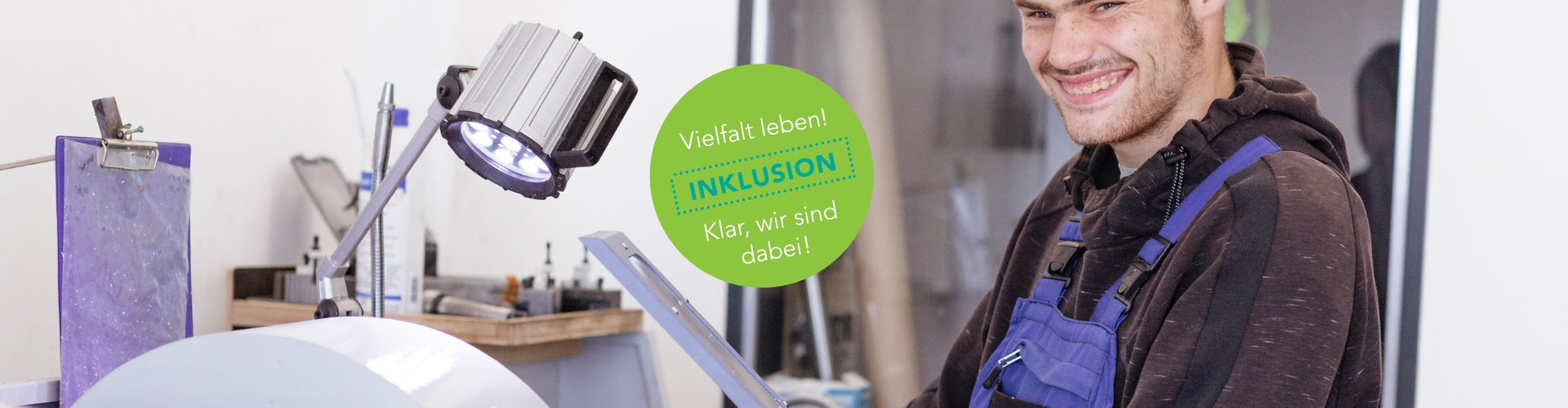 Junger, lächelnder Mann an Maschine