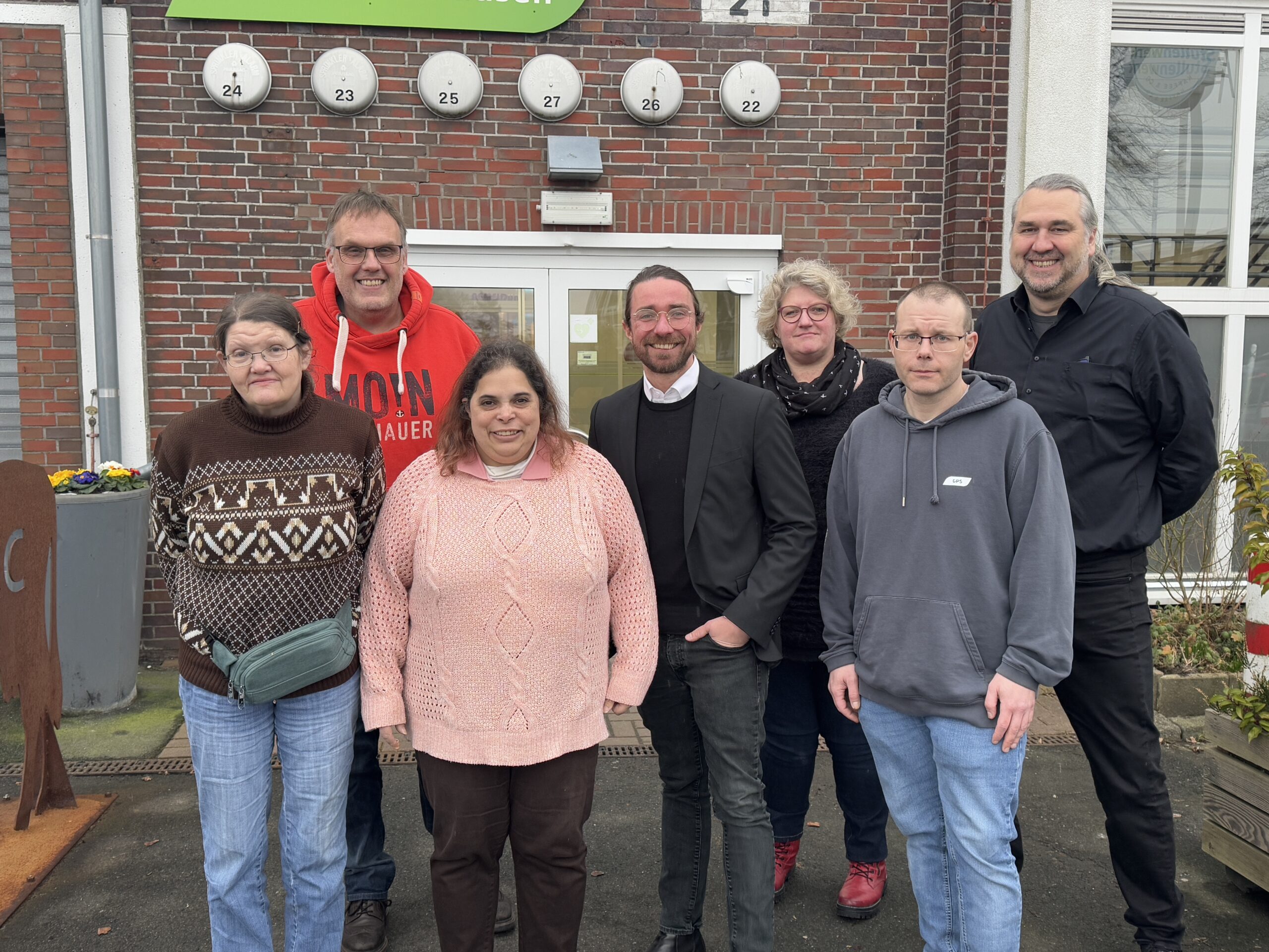 Gruppenfoto draußen mit dem Geschäftsführer der GPS, ein junger Politiker, eine GPS-Mitarbeiterin, der Leiter der GPS Werkstatt ARTEC Roffhausen und drei Beschäftigte der Werkstatt.